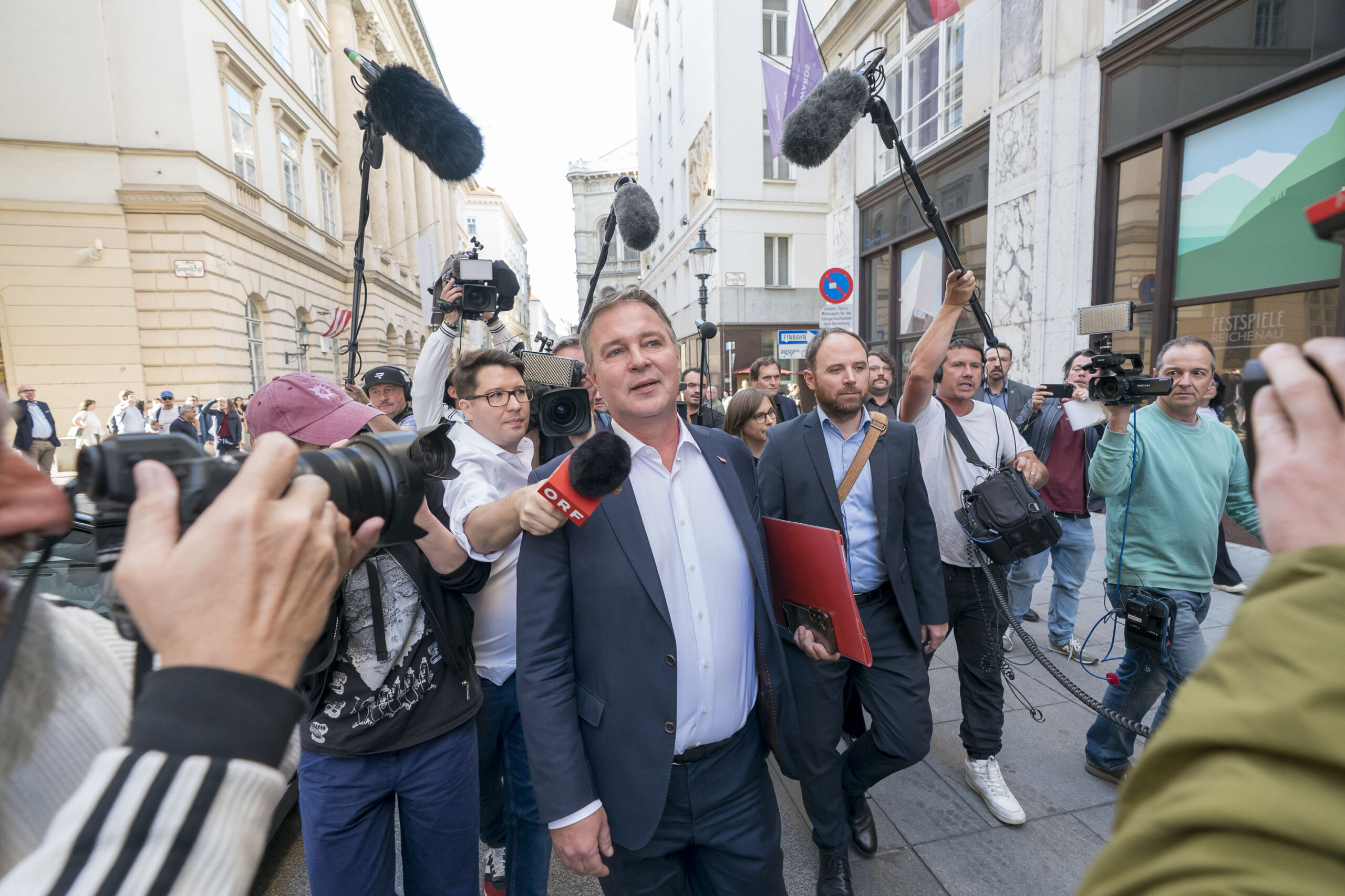 Andreas Babler umringt von Kameraleuten und Reportern vor dem Hotel Steigenberger in Wien