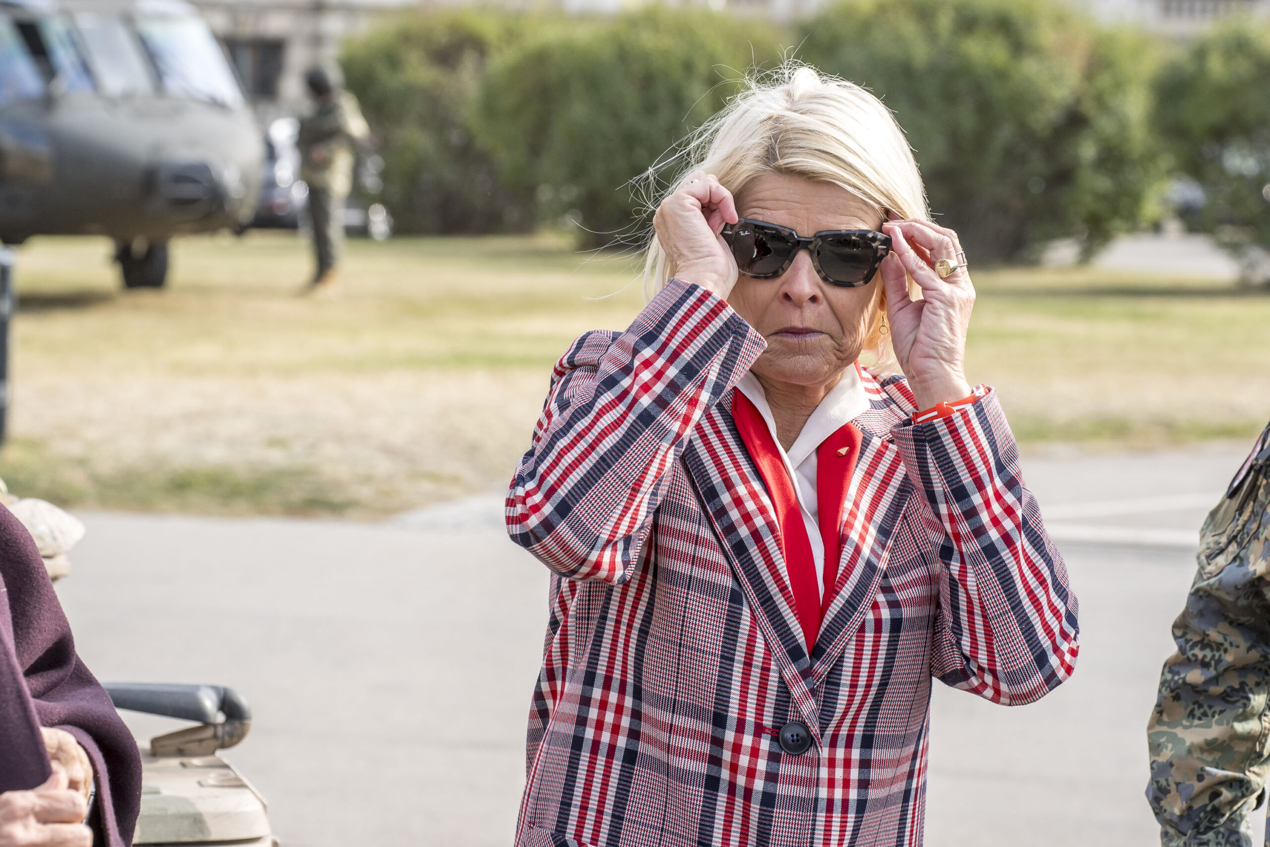 Verteidigungsministerin Klaudia Tanner setzt sich eine Sonnenbrille auf